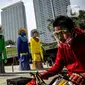 Pesepeda melintasi ondel-ondel yang dipasang di Taman Ismail Marzuki (TIM), Jakarta, Selasa (22/6/2021). Sebanyak 10 ondel-ondel raksasa setinggi 4,94 meter akan dipamerkan di TIM saat peringatan HUT ke-494 DKI Jakarta yang berlangsung dari 22 hingga 30 Juni 2021. (Liputan6.com/Faizal Fanani)