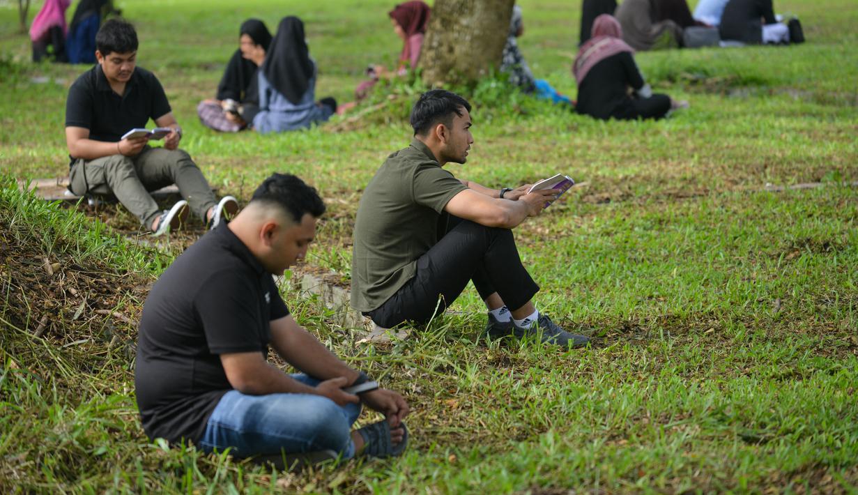 Orang-orang berdoa saat memperingati 18 tahun musibah gempa dan tsunami di kuburan massal Siron, Aceh, Senin (26/12/2022). Sejumlah warga mendatangi Kuburan Massal Siron untuk memenjatkan doa saat peringatan 18 tahun musibah gempa dan tsunami Aceh 2004. (AFP/Chaideer Mahyuddin)