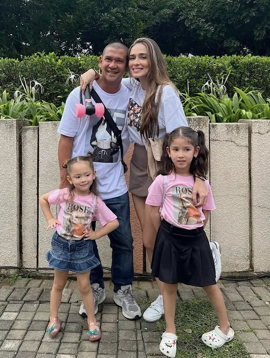 Yasmine Wildblood mengenakan atasan putih dengan mini skirtnya. Mengajak kedua buah hatinya yang menggemaskan mengenakan koas pink dengan foto Jisoo.  (@yaswildblood)