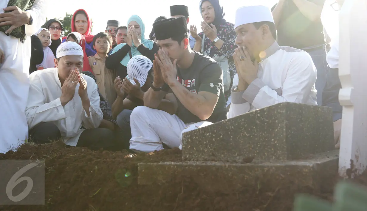 Aktor Iko Uwais berdoa di depan makam ayahnya Musthafa Kamaluddin di TPU Prumpung, Jakarta, Rabu (8/3). Ayahanda Iko Uwais itu meninggal dunia di usia 78 tahun karena sakit. (Liputan6.com/Herman Zakharia)