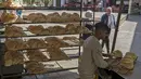 Pria Mesir bekerja di sebuah toko roti di sebuah pasar di Kairo, pada 17 Maret 2022. Melonjaknya harga roti yang dipicu oleh invasi Rusia ke Ukraina telah menggigit daya beli konsumen di Mesir, importir gandum terkemuka dari negara-negara bekas Soviet. (Khaled DESOUKI / AFP)