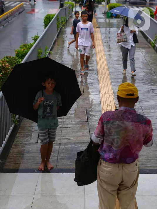 Mereka rela berhujan-hujan untuk mendapat rejeki tambahan yang akan digunakan untuk kebutuhan sehari-hari. (Liputan6.com/Angga Yuniar)