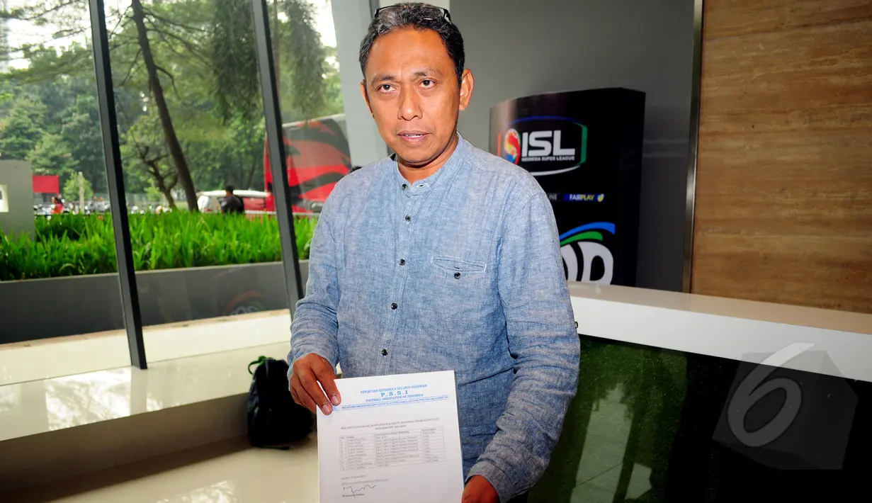 Ketua Komisi Banding M. Muhdar memperlihatkan kertas rekapitulasi hasil keputusan Komite Banding Pemilihan exco PSSI periode 2015-2019 di kantor PSSI, Jakarta, Kamis (19/3/2015). (Liputan6.com/Yoppy Renato)