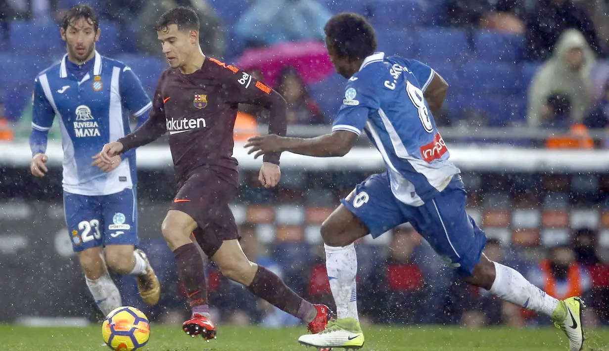 Aksi pemain FC Barcelona, Coutinho (tengah) melewati dua pemain Espanyol pada lanjutan La Liga santander di RCDE stadium, Cornella Llobregat, Spanyol, (4/2/2018). Espanyol dan Barcelona bermain imbang 1-1. (AP/Manu Fernandez)