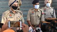Polisi negara bagian Punjab saat berbicara kepada media di distrik Tarn Taran pada 1 Agustus 2020, setelah puluhan orang meninggal karena mengkonsumsi miras ilegal beracun (AFP Photo/NARINDER NANU)