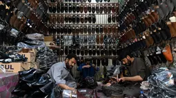 Di sisi lain, kesibukan juga terjadi di salah satu bengkel perajin sepatu tradisional di Lahore, Pakistan. Tampak dalam foto, aktivitas para perajin sepatu membuat sandal di sebuah bengkel menjelang perayaan Idul Fitri selama bulan suci Ramadan 1447 Hijriah di Lahore pada 14 Maret 2026. (Arif ALI/AFP)
