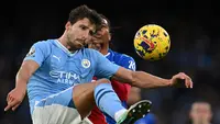 Bek Manchester City Ruben Dias berusaha untuk mengontrol bola dan dijaga pemain Crystal Palace (AFP)