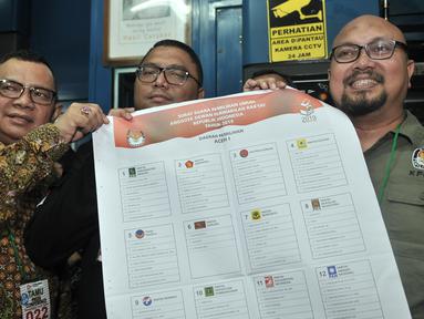 Komisioner KPU Ilham Saputra didampingi Anggota Bawaslu Fritz Edward dan Pihak Politeknik Media Kreatif menunjukkan surat suara legislatif kepada awak media saat pencetakan perdana di Kompas Gramedia, Jakarta, Minggu (20/1). (Merdeka.com/Iqbal S. Nugroho)