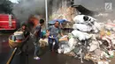 Warga mengangkut barang-barang berharga saat kebakaran melanda sebuah gudang di Jalan Kampung Bandan, Ancol, Jakarta Utara, Kamis (5/7). Kebakaran terjadi pada pukul 13.25 WIB. (Kapanlagi.com/Budy Santoso)