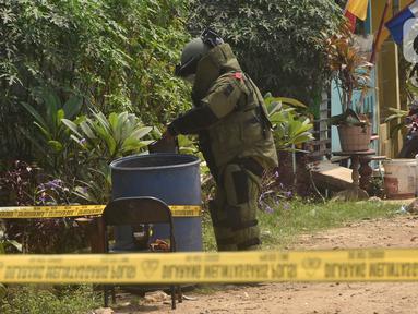Tim penjinak bom sedang memeriksa tong sampah di Kawasan Caman, Bekasi, Jawa Barat, Senin (23/8/2021). Benda mencurigakan tersebut menyerupai bom tetapi tidak mengandung bahan peledak. (Liputan6.com/Herman Zakharia)