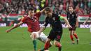 Aksi Luka Modrid melewati pemain Hungaria, Adam Szalai pada laga kedua babak kualifikasi Piala Eropa 2020 Grup E yang berlangsung di Stadion Groupama Arena, Budapest, Senin (25/3). Kroasia kalah 1-2 kontra Hungaria. (AFP/Attila Kisbenedek)
