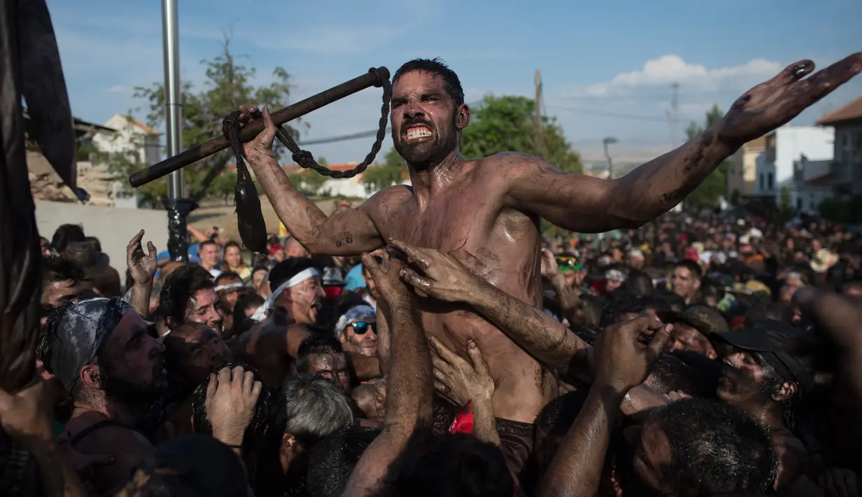 Peserta berlumuran oli saat mengikuti Festival Cascamorras di Baza, Granada, Spanyol, Kamis (6/9). Festival tradisional ini berlangsung setiap tanggal 6 September. (JORGE GUERRERO/AFP)