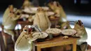 Model katak menggambarkan sedang makan bersama yang dipamerkan di Museum Katak di Estavayer-le-Lac, Swiss barat (22/6). Museum ini memamerkan koleksi yang menceritakan kehidupan manusia sehari-hari. (AFP Photo/Fabrice Coffrini)