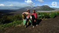 Warga merawat tanaman daun bawang yang dapat dipanen setahun tujuh kali di kebun dengan latar belakang Gunung Bromo di Seruni Point, Pasuruan, Jawa Timur, Minggu (30/4/2023). (merdeka.com/Arie Basuki)