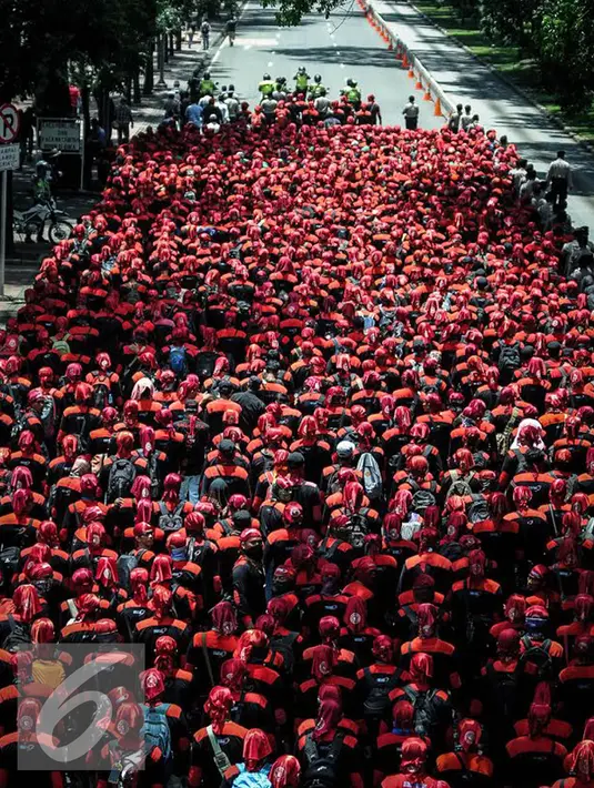 Ribuan buruh berjalan menuju Istana Negara, Jakarta, Kamis (29/9). Dalam aksinya mereka menolak Tax Amnesty serta menaikan upah minumum provinsi (UMP) sebesar Rp650 ribu per bulan. (Liputan6.com/Faizal Fanani)