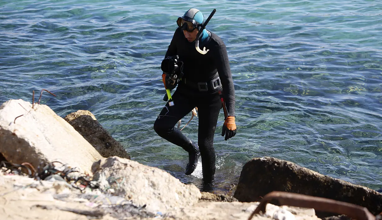 Salem Abu Amerah usai menyelam menangkap ikan di laut di pelabuhan  Kota Gaza (20/12/2019). Salem Abu Amerah mencari ikan untuk membantu keluarganya. (AP Photo/Hatem Moussa)