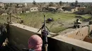Anggota Syrian Democratic Forces (SDF) mengintai militan ISIS dari sebuah bangunan di kantong terakhir kekhalifahan di Baghouz, Suriah, Senin (18/2). ISIS dilaporkan kian terkepung. (AP Photo/Felipe Dana)