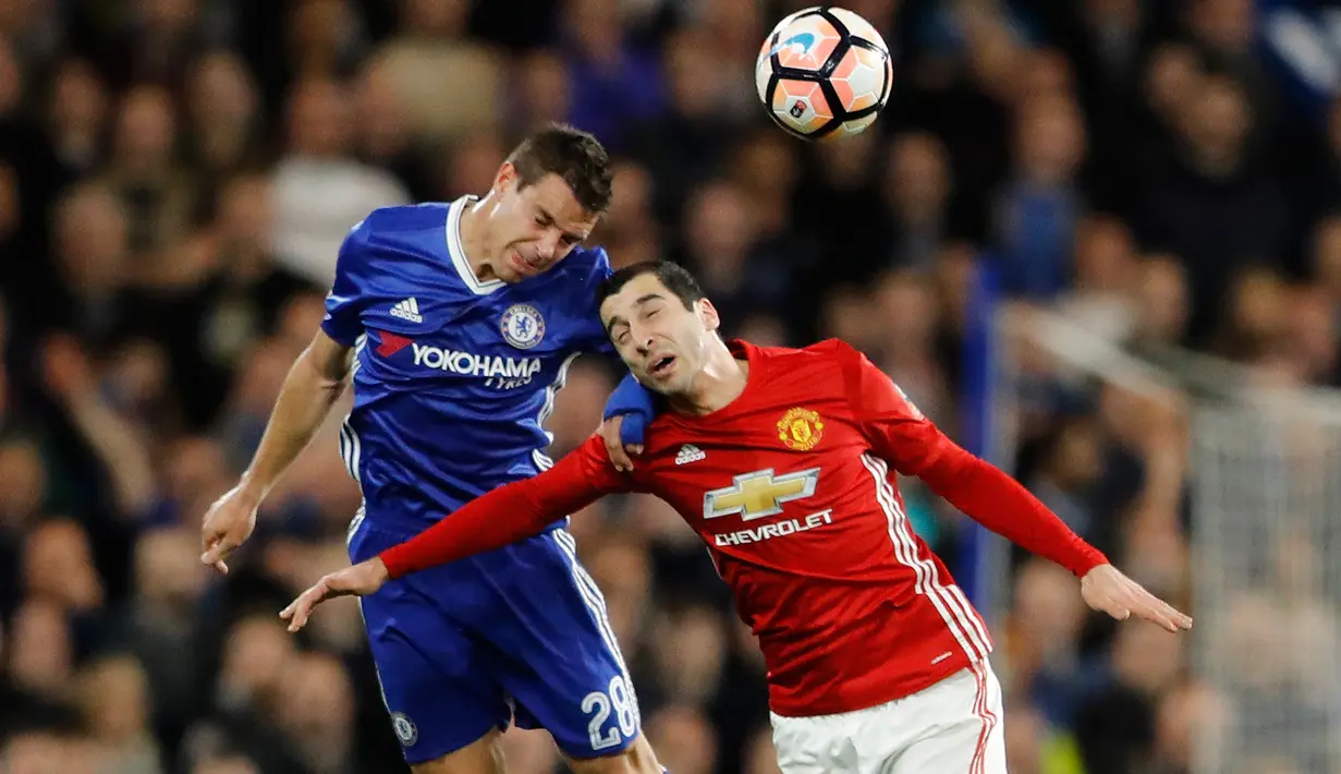 Pemain Chelsea, Azpilicueta dan pemain Manchester United, Henrikh Mkhitaryan berebut bola dalam perempat final Piala FA di Stadion Stamford Bridge, Senin (13/3). Chelsea lolos ke semifinal Piala FA setelah menang 1-0 atas MU. (AP Photo/Frank Augstein)