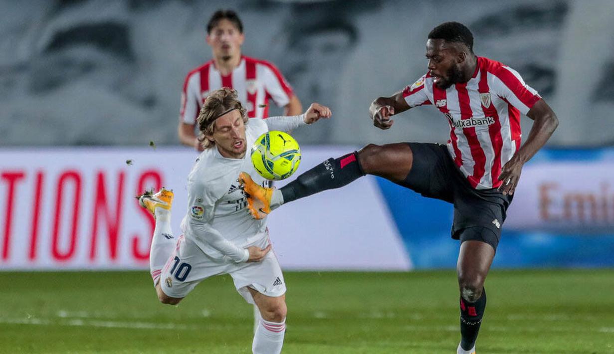 Gelandang Real Madrid, Luka Modric, berebut bola dengan pemain Athletic Bilbao, Inaki Williams, pada laga Liga Spanyol di Stadion Alfredo Di Stefano, Rabu (16/12/2020). Real Madrid menang dengan skor 3-1. (AP/Bernat Armangue)