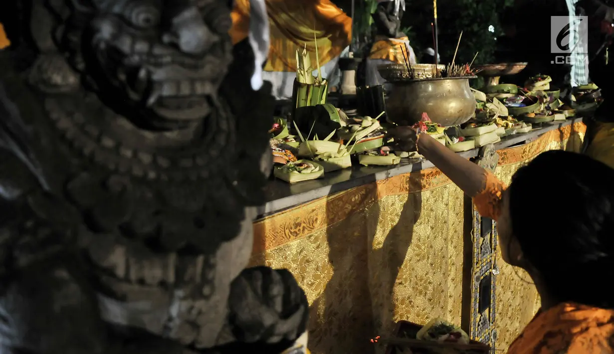 Umat Hindu meletakkan sesaji saat sembahyang malam (Tilem Kesanga) menjelang Nyepi Tahun Baru Saka 1941 di Pura Aditya Jaya, Jakarta, Rabu (6/3). Sembahyang Tilem Kesanga merupakan salah satu rangkaian ibadah menjelang Nyepi. (merdeka.com/Iqbal S Nugroho)