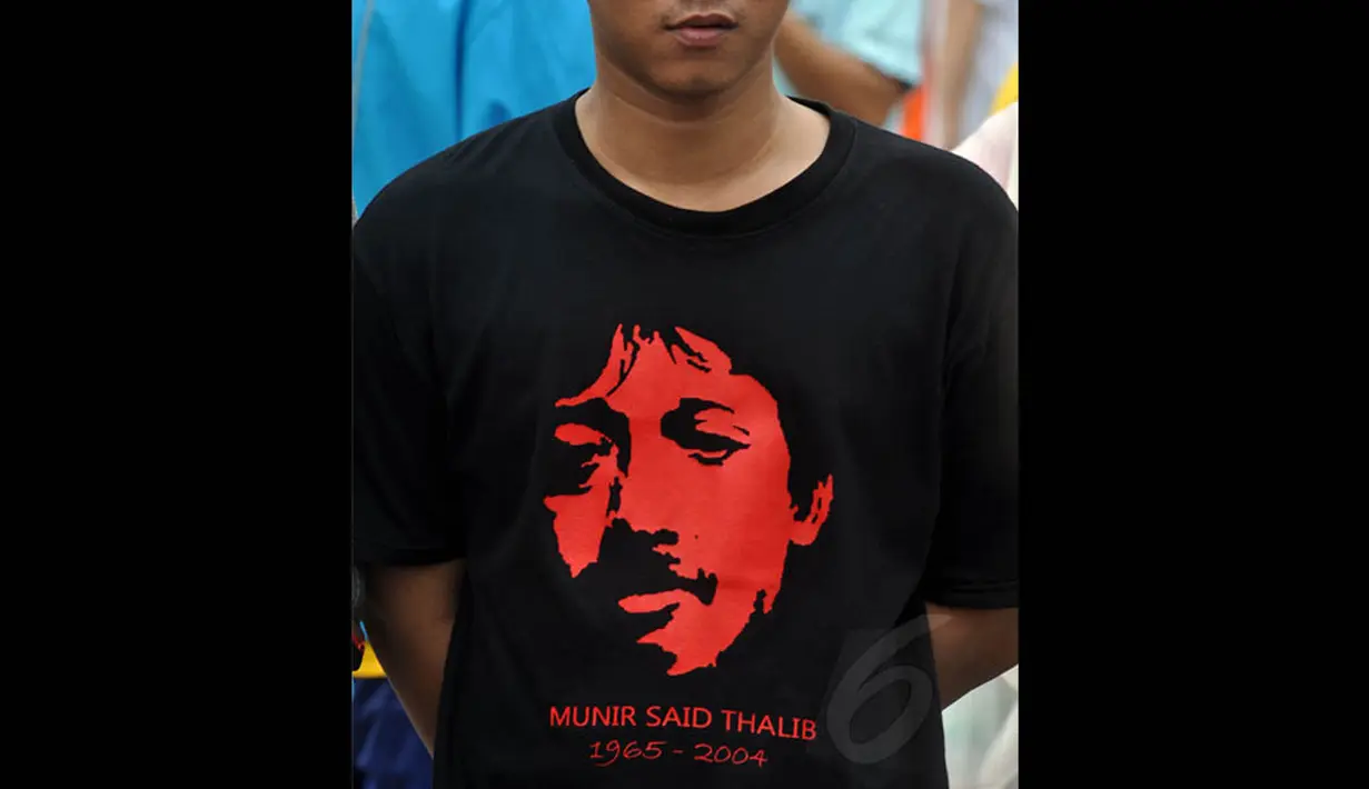 Seorang aktivis memakai kaos bergambar Munir saat aksi damai di Bundaran HI, Jakarta, Minggu (7/12/2014). (Liputan6.com/Miftahul Hayat)