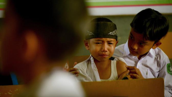 Anak menangis usai disuntik(CHAIDEER MAHYUDDIN/AFP)