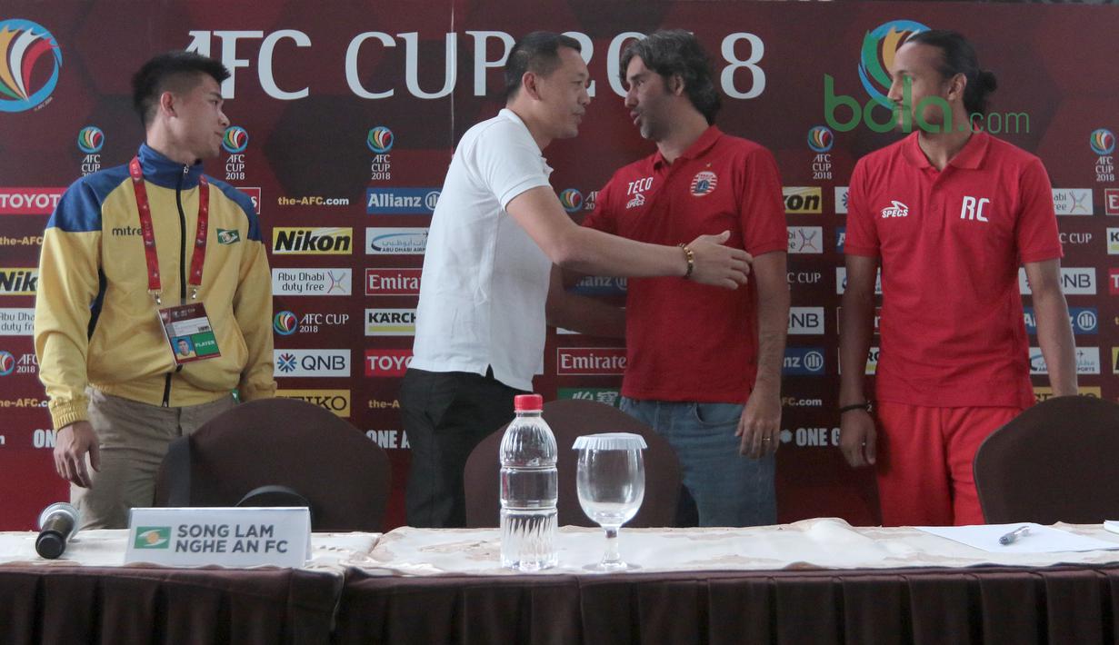 Stefano Teco (2kanan) memeluk Pelatih Song Lam Nghe An FC, Nguyen Duc Thang (2kiri) usai konferensi pers Piala AFC 2018 di Hotel Grandika, Jakarta, (13/3/2018). Persija akan melawan Song Lam Nghe AN FC. (Bola.com/Nick Hanoatubun)