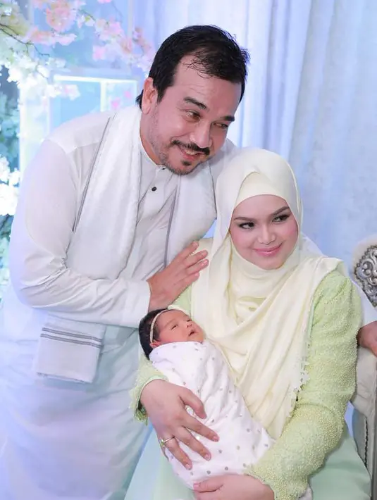 Penyanyi Siti Nurhaliza bersama Datuk Seri Khalid menggendong anak pertama meraka Siti Aafiyah saat acara akikah. Selain akikah, Siti Nurhaliza dan suami juga mengumumkan nama asli anak perempuan pertamanya tersebut. (instagram.com/ctdk)
