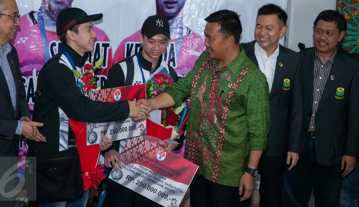 Kemenpora memberikan bonus sebesar 250 juta kepada Kevin dan Marcus saat tiba di Bandara Internasional Soekarno Hatta, Tangerang, Banten, Selasa (14/3). Kevin dan Marcus adalah juara ganda putra All England 2017. (Liputan6.com/Gempur M Surya)