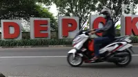 Pengendara motor melintasi Jalan Ir Djuanda, Kota Depok, Jawa Barat, Minggu (12/4/2020). Menteri Kesehatan menyetujui menerapkan Pembatasan Sosial Berskala Besar (PSBB) di wilayah Kota Depok yang akan dimulai, Rabu (15/4) dalam pencegahan meluasnya COVID-19. (Liputan6.com/Helmi Fithriansyah)