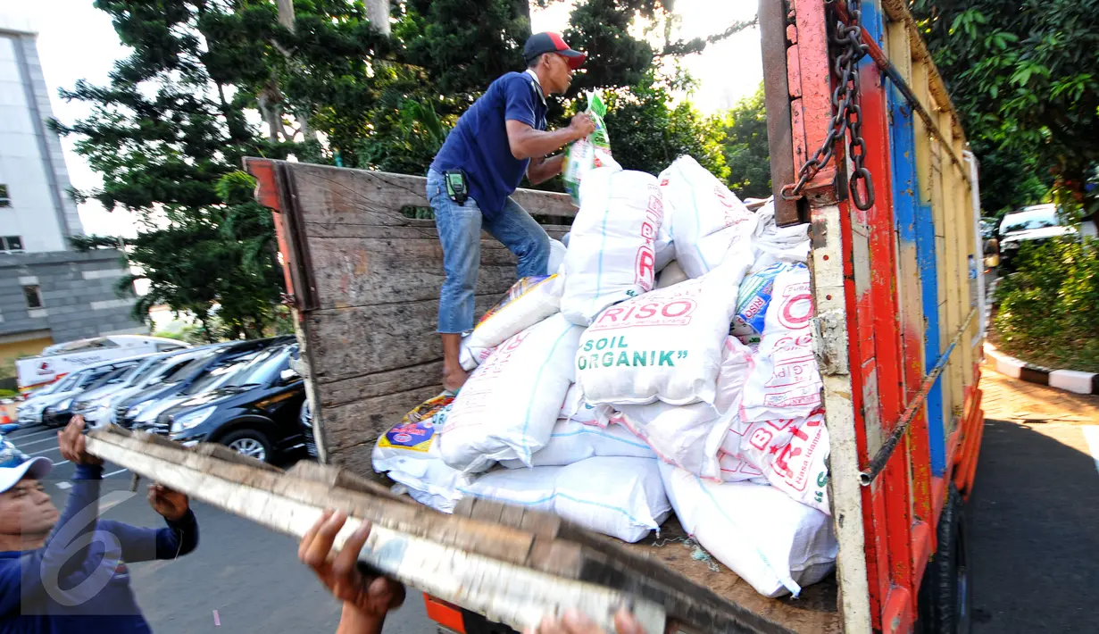 Beras oplosan sebanyak 50 ton diamankan Polda Metro Jaya, Jakarta, Jumat (26/6/2015). Tampak pekerja sedang memasukkan beras ke dalam truk. (Liputan6.com/Yoppy Renato)