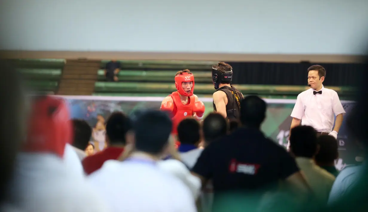 Dua Atlet Wushu saat bertanding pada Cabang Sanda Kejuaraan Dunia Wushu 2015 di Istora, Senayan, Jakarta,Rabu (18/11/2015). (Bola.com/Nicklas Hanoatubun)