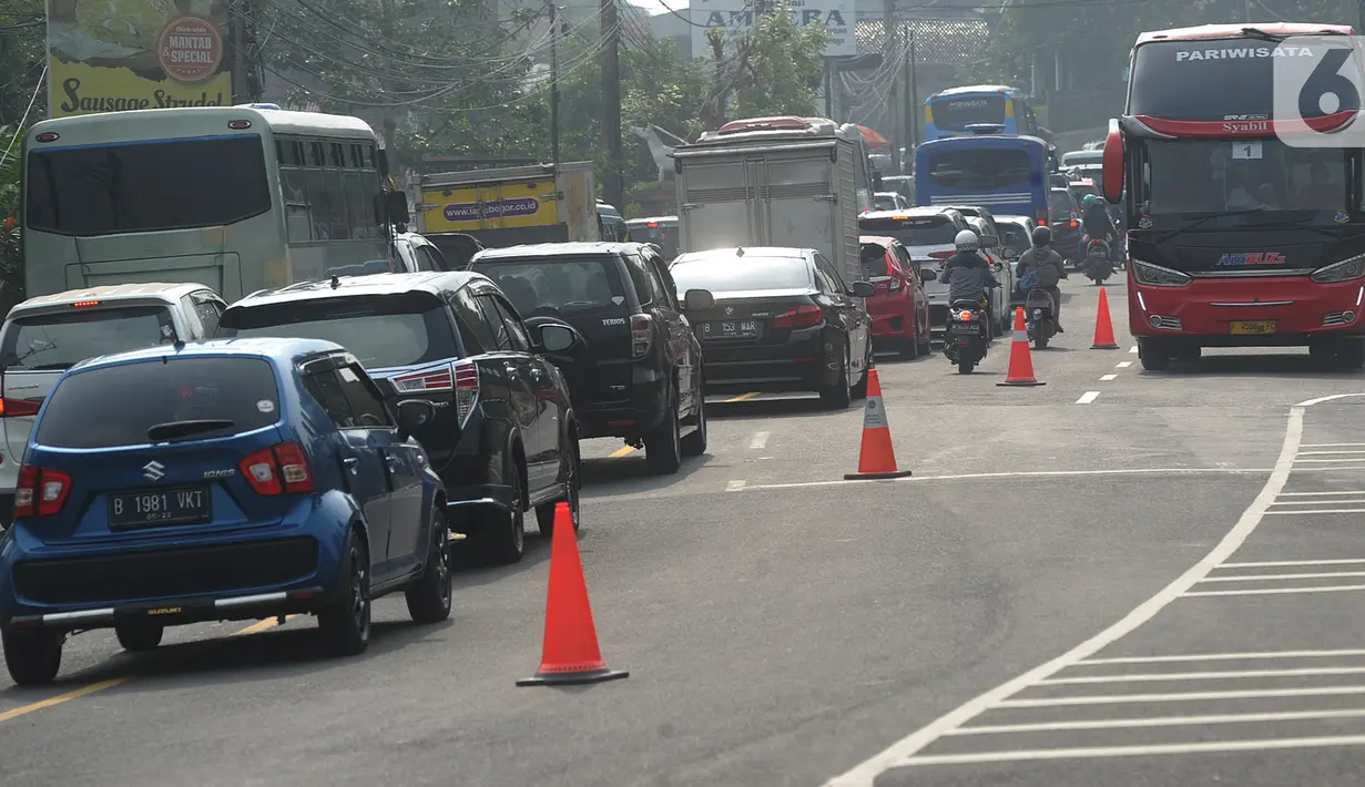 Kondisi lalu lintas saat saat uji coba sistem kanalisasi 2-1 Jalur Puncak di kawasan Gadog, Bogor, Jawa Barat, Minggu (27/10/2019). Pemberlakuan sistem kanalisasi 2-1 Jalur Puncak sebagai alternatif dari sistem buka-tutup yang telah diberlakukan selama ini. (merdeka.com/Arie Basuki)