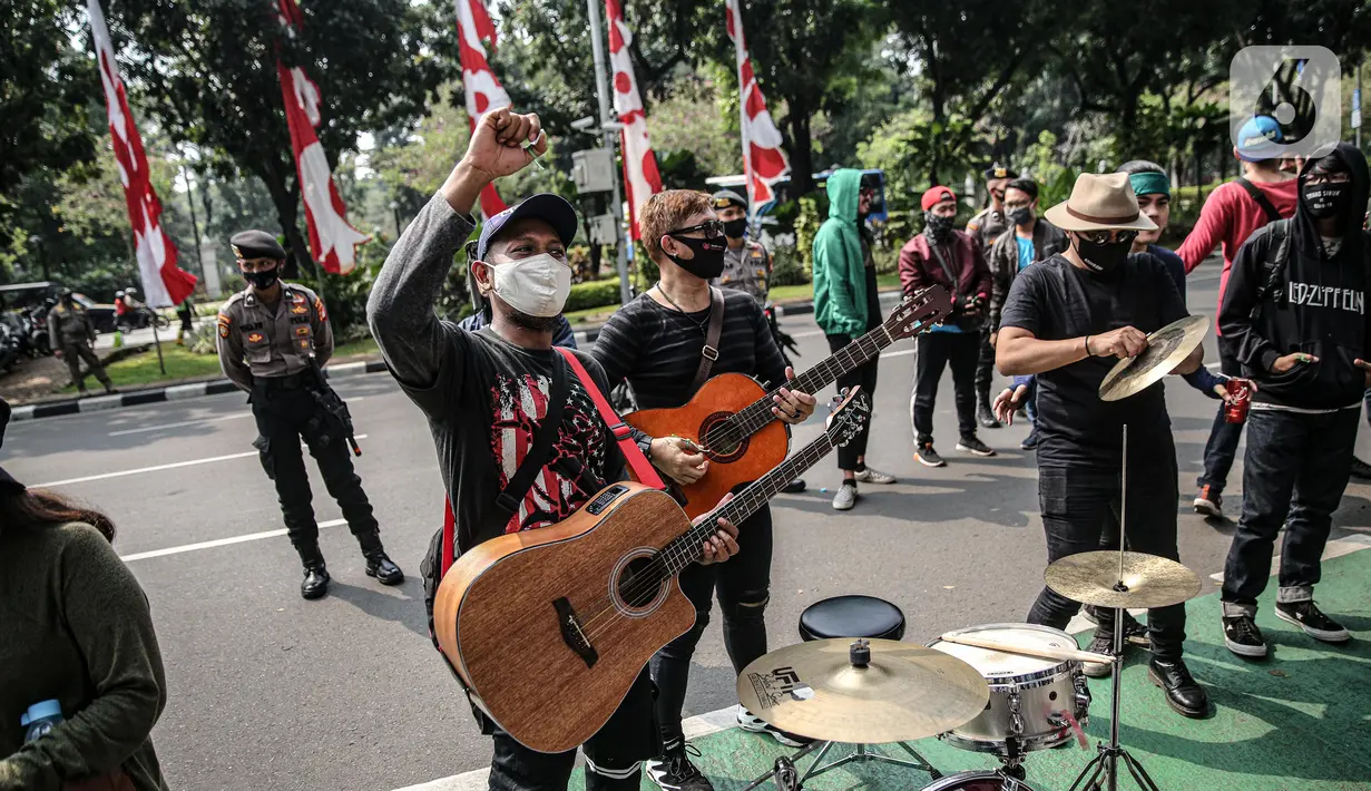 Sejumlah musisi kafe saat melaksanakan aksi di depan Balai Kota Jakarta, Rabu (8/7/2020). Aksi ngamen di depan Balai Kota Jakarta yang diikuti oleh musisi kafe itu untuk menyuarakan aspirasi pekerja seni harian yang terdampak mata pencahariannya selama masa PSBB. (Liputan6.com/Faizal Fanani)