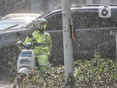 Pengendara motor mengenakan jas pelindung saat hujan mengguyur kawasan Monas, Jakarta Pusat, Kamis (5/1/2023). Badan Meteorologi, Klimatologi, dan Geofisika (BMKG) menyatakan beberapa wilayah Indonesia seperti Sumatera bagian selatan, Jawa, dan Bali mulai memasuki periode puncak musim hujan. (merdeka.com/Iqbal S Nugroho)