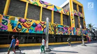 Sejumlah warga berjalan di dekat karya seni Mural di Taman Ismail Marzuki (TIM), Cikini, Jakarta, Selasa (11/9). Mural tersebut dibuat oleh seniman asal Kolombia Diana Ordonez. (Liputan6.com/Faizal Fanani)