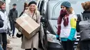 Pamela Anderson kerdus yang berisi barang yang akan disumbangkan untuk pengungsi di Grande-Synthe, Prancis (25/1). Dalam kunjungannya, Pamela menyumbangkan buku anak-anak, makanan serta perlengkapan lainnya. (AFP/Philippe Huguen)