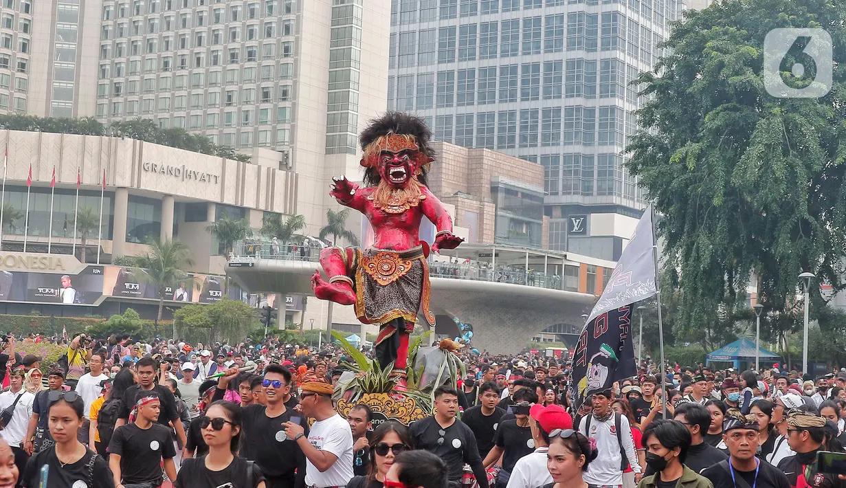 Umat Hindu mengarak ogoh-ogoh saat hari bebas berkendara di kawasan Bundaran HI, Jakarta, Minggu (12/3/2023). Pawai ogoh-ogoh tersebut diselenggarakan dalam rangka menyambut Perayaan Nyepi Tahun Baru Saka 1945/2023. (Liputan6.com/Angga Yuniar)