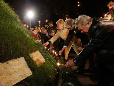 Sejumlah orang menyalakan lilin sebelum dimulai upacara peringatan 28 tahun bencana nuklir Chernobyl, di Kiev, Ukraina (26/4/2014). (REUTERS/Valentyn Ogirenko)