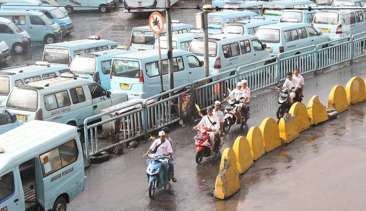Pengendara sepeda motor melintasi jalur angkutan umum di Terminal Kampung Melayu, Jakarta, Rabu (6/2). Meskipun terdapat larangan melintas bagi pemotor, namun masih ada sejumlah pengendara nekat menerobos masuk terminal. (Liputan6.com/Immanuel Antonius)