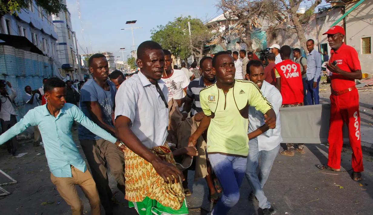 Warga mengevakuasi korban serangan bom mobil di luar Hotel Weheliye, Mogadishu, Somalia, (22/3). Kelompok teroris Ash-Shabaab, yang berafiliasi jaringan Al-Qaeda, mengaku bertanggung jawab atas serangan tersebut. (AP Foto/Farah Abdi Warsameh)