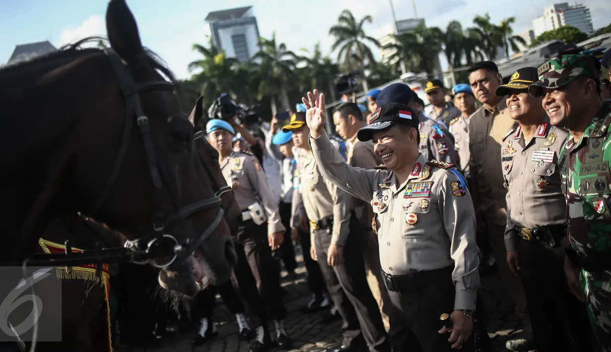 Kapolri Jenderal Tito Karnavian menyapa seorang pasukan polisi berkuda saat Apel Gelar Pasukan Operasi Lilin Jaya 2017 di Lapangan Silang Monas, Jakarta, Kamis (22/12). (Liputan6.com/Faizal Fanani)
