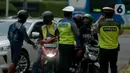 Polisi mengimbau pengguna jalan yang menggunakan kendaraan pribadi mobil dan motor yang berboncengan di Bundaran HI, Jakarta, Jumat (10/4/2020). Penerapan hari pertama PSBB hingga 14 hari kedepan ini dilakukan untuk mencegah penyebaran COVID-19 dan selalu menggunakan masker.(merdeka.com/Imam Buhori)