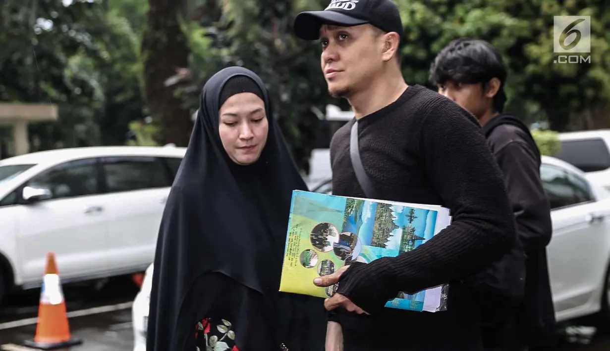 Lyra Virna dan suaminya Fadlan saat tiba di Ditreskrimsus Polda Metro Jaya, Jakarta, Kamis (22/3). Lyra datang untuk memenuhi panggilan terkait statusnya sebagai tersangka kasus dugaan pencemaran nama baik sebuah travel umrah. (Liputan6.com/Faizal Fanani)