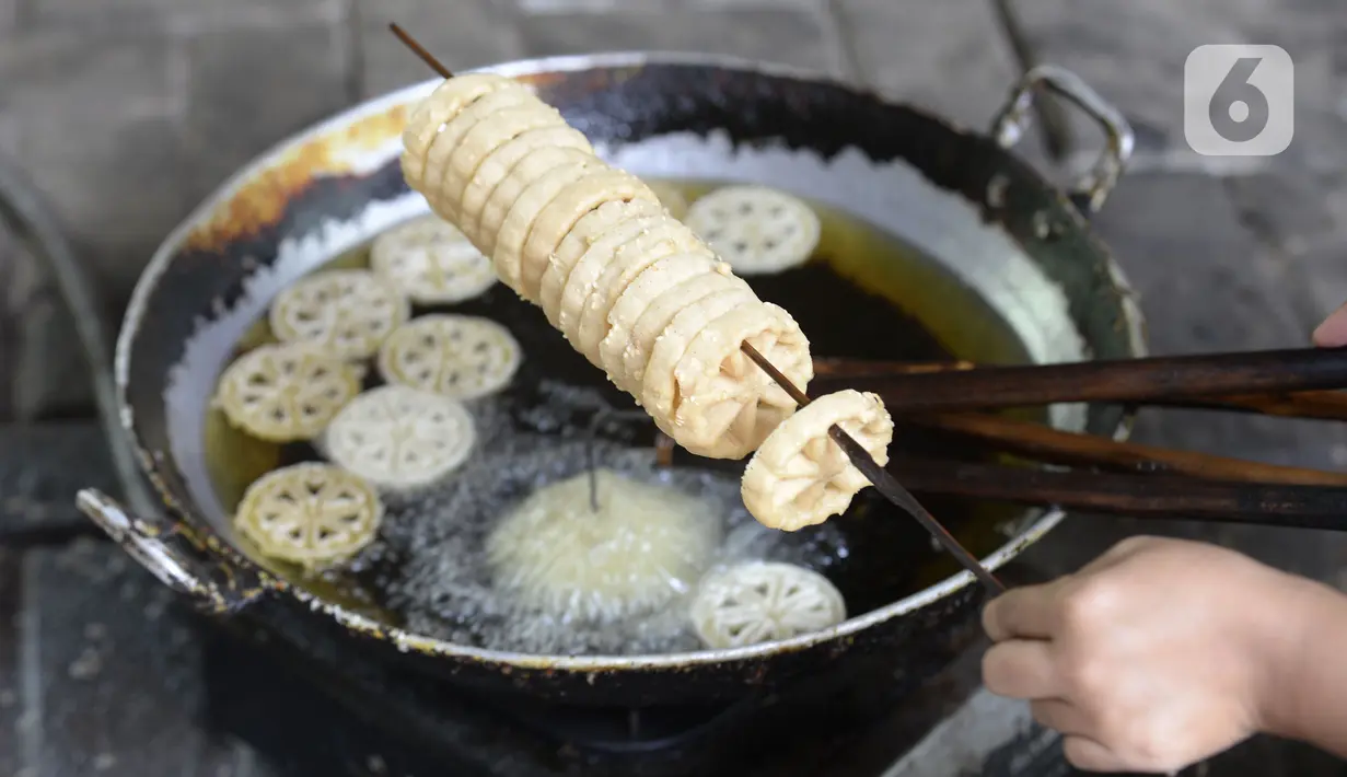 Pekerja menggoreng jajanan tradisional kembang goyang di Kelurahan Karangan, Setu, Tangerang Selatan, Banten, Kamis (6/8/2020). Jajanan kue kering berbentuk bunga tersebut dijual dengan harga Rp 5 ribu per bungkus. (merdeka.com/Dwi Narwoko)