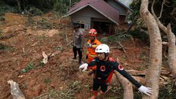 Gambar selebaran yang diambil pada 8 Maret 2023 dan dirilis pada 9 Maret 2023 oleh Badan Penanggulangan Bencana Indonesia ini menunjukkan tim SAR terlihat di lokasi tanah longsor di desa Pangkalan, Natuna, Kepulauan Riau (Kepri). Sementara sebanyak 33 orang dinyatakan hilang terrimbun longsoran. (HO / INDONESIA DISASTER MITIGATION AG / AFP)