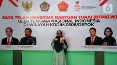 Warga menunjukkan uang dan KTP usai menerima Bantuan Tunai untuk Pedagang Kaki Lima dan Warung (BTPKLW) di Markas Kodim 0508/Depok, Jawa Barat, Rabu (20/10/2021). Kodim 0508/Depok menyalurkan batuan sebesar Rp 1,2 juta per kepala dari pemerintah pusat. (merdeka.com/Arie Basuki)