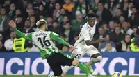 Bek Real Betis, German Pezzella (Kiri) berusaha merebut bola dari penyerang Real Madrid, Vinicius Junior selama pertandingan La Liga Spanyol di stadion Benito Villamarin di Seville, Senin (6/3/2023). Real Madrid bermain imbang dengan Real Betis dengan skor 0-0. (AFP/CRISTINA QUICLER)