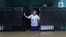 Warga melihat situasi dari pagar rumah saat banjir di RW 07, Kelurahan Pekayon, Jakarta Timur, Sabtu (20/2/2021). Banjir di kawasan tersebut terjadi akibat curah hujan yang tinggi. (Liputan6.com/Herman Zakharia)