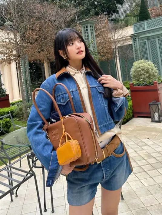 Minnie membawa tas coklat Miu Miu. Dengan rambut panjang terurai berponi depan. Dan makeup natural nya.  [@min.nicha]